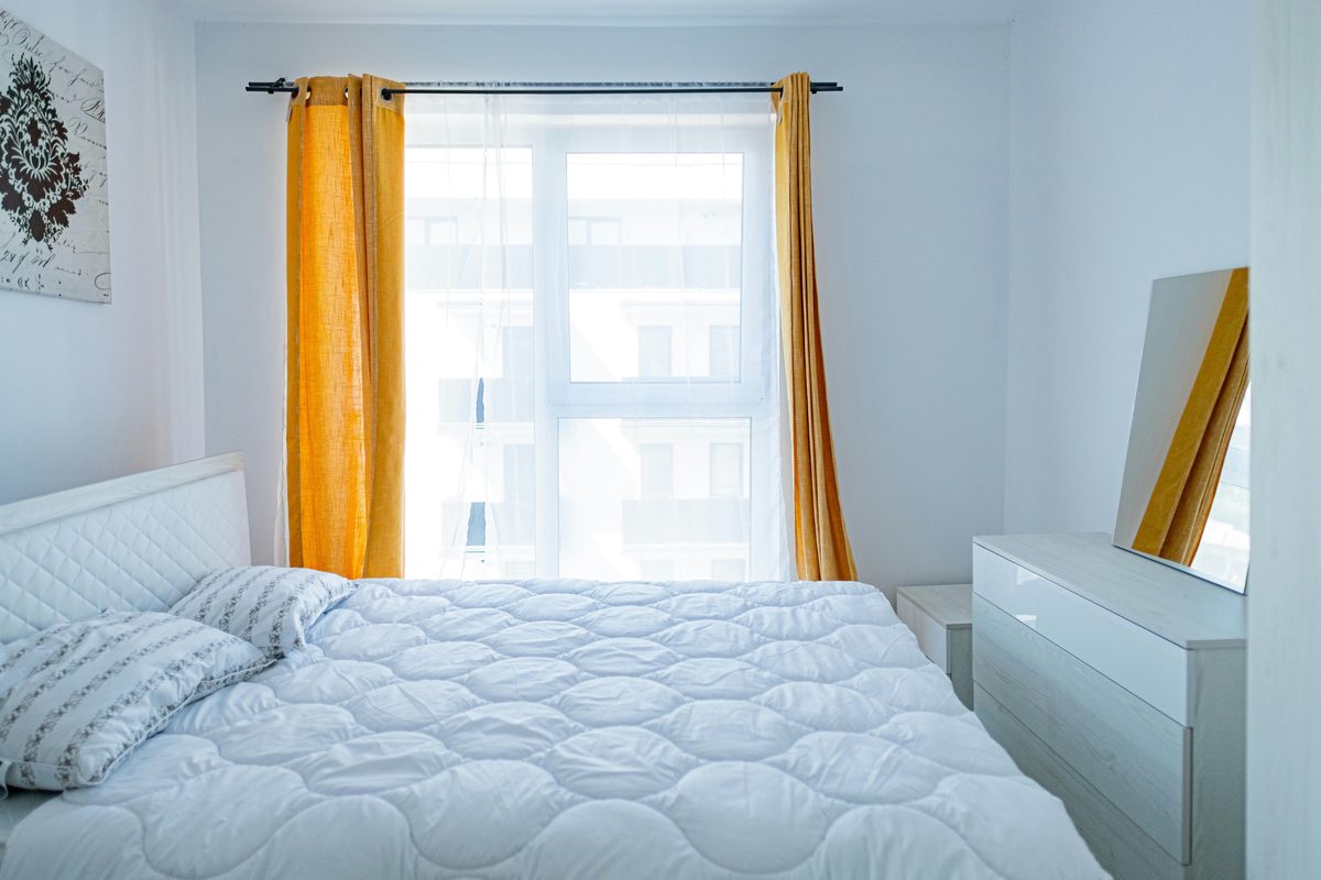 Cama tendida en una habitación iluminada